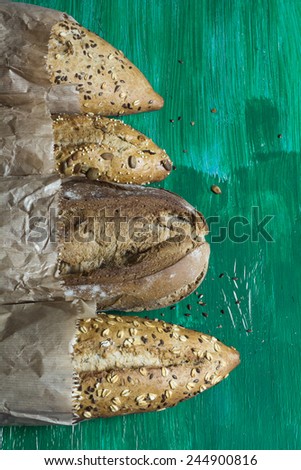 Variety of breads with seeds and nuts, on green grunge background