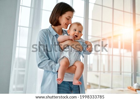 Similar – Image, Stock Photo Mom breastfeeding baby and writing in copybook in house