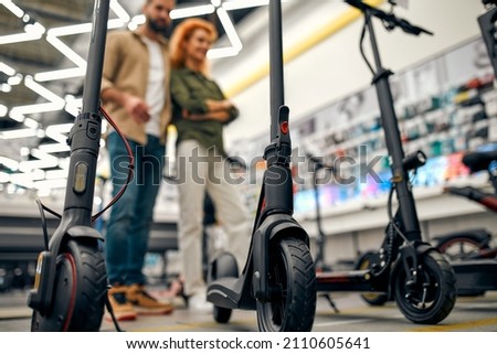 Similar – Image, Stock Photo Electric scooter with shopping bags and woman in background.