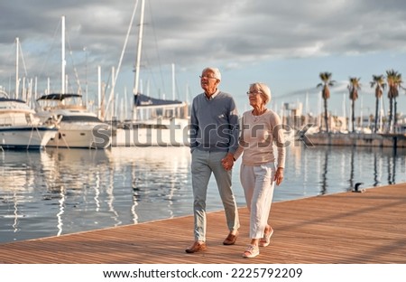 Similar – Image, Stock Photo Senior lady admiring sunset over ocean from boardwalk