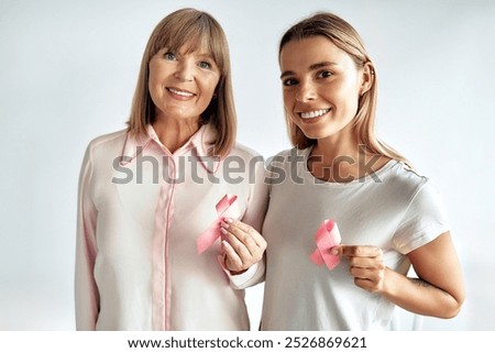 Foto Bild Eine Frau mit pinken Gummistiefeln gießt mit einer Gieskanne den Rasen