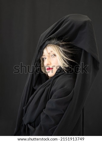 Similar – Image, Stock Photo proud blonde fashion beauty model woman, with red mouth and black fabric, cloth with hair electrostatic charged, sticking to cape, against black background