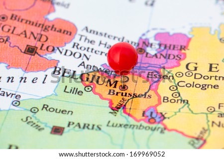 Round red thumb tack pinched through Brussels on Belgium map. Part of collection covering all major capitals of Europe.