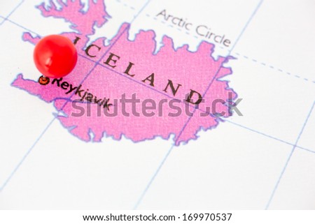 Round red thumb tack pinched through city of Reykjavik on Iceland map. Part of collection covering all major capitals of Europe.