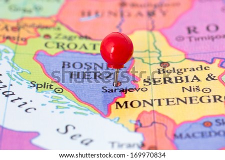 Round red thumb tack pinched through city of Sarajevo on Bosnia-Hercegovina map. Part of collection covering all major capitals of Europe.
