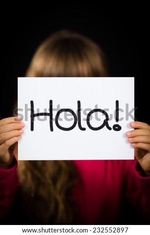 Studio shot of child holding a sign with Spanish word Hola - Hello