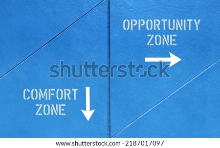 Blue wall with direction sign and text written COMFORT ZONE and OPPORTUNITY ZONE, means to step out of comfortable feel safe situation to explore and try new things Imagine de stoc © 