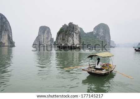 HA LONG BAY, VIETNAM - MAY 25: Unidentified woman sells fruits from her boat on Ha Long bay, Vietnam on May 25, 2011. Floating markets are very popular as it is only way to move around.