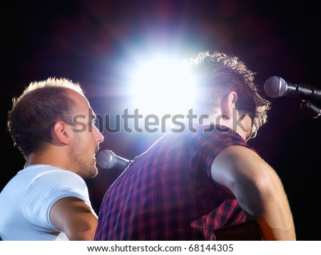 Two musicians on stage under the spotlight during the concert...