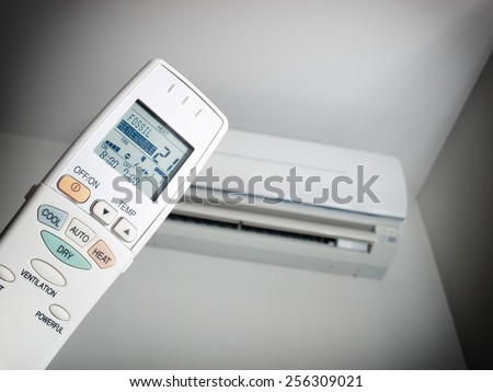 Remote control with two choices of energy source and with an air condition device in the background.