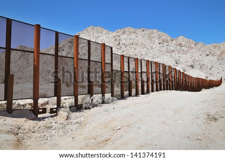 Large steel fence protecting the border between Mexico and the United States of America at the Tinajas Altas Mountains in Arizona (Sonoran Desert). Common place for illegals & drug smugglers to cross.