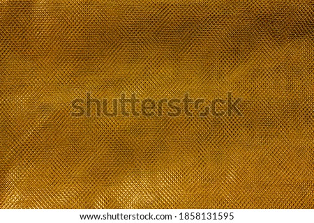 The texture of a thin nylon transparent fabric close-up in Fortuna Gold color. Pattern, background in color trend 2021 Foto stock © 