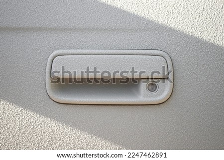 Door handle on a white car door coated with a 2-component heavy-duty protective paint for extreme conditions, raptor paint. Stockfoto © 