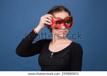 A young girl on a blue background. trying on a mask
