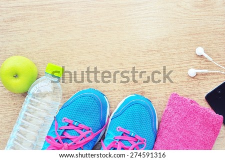 Sport shoes and water with set for sports activities on tiled floor.