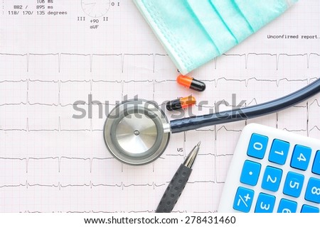 Medicine,Stethoscope and calculator on electrocardiogram paper.Health care costs.