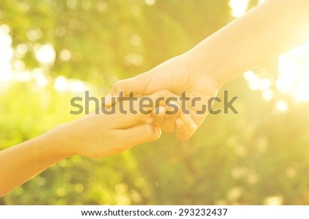 Soft focus photo, couple holding hands in the sunset.