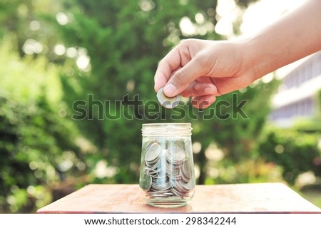 Woman hand putting money coin stack growing business.