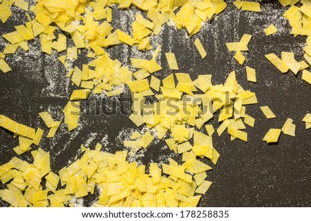 Grandmother\'s home made pasta on black surface, beautiful yellow black background