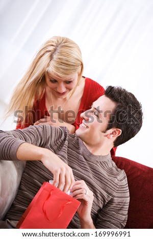 Fun Valentine's Day Holiday series with young Caucasian couple sitting around exchanging gifts.
