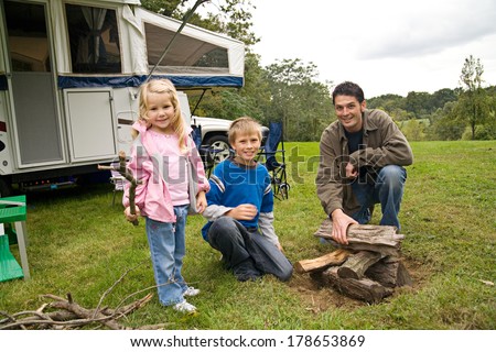 Camping: Dad And Kids Work On Campfire