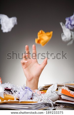 Business: Hand Reaches Up From Paper Pile