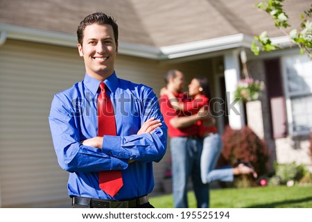 Home: Agent With Successful Home Sellers In Background