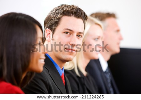 Office: Serious Businessman Looks To Camera During Meeting