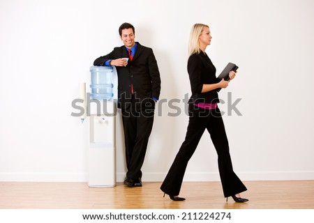 Office: Businessman Flirts With Coworker By Water Cooler