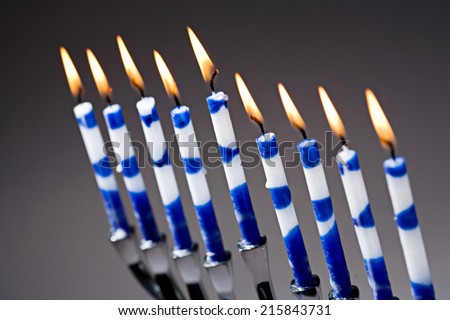 A silver Hanukkah menorah with lit blue and white candles.