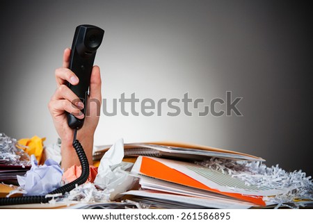 Business: Man Holding Up Phone From Pile Of Paper