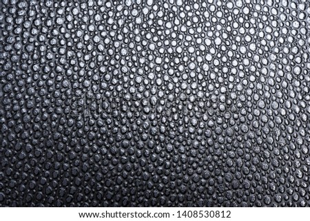 The raised detailed texture o a faux black leather with gradual shifting directional lighting as background material. Foto stock © 