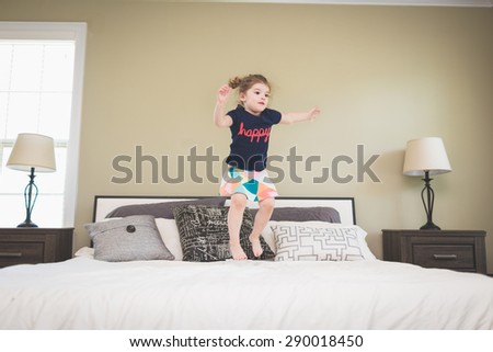 Little girl jumping on the bed