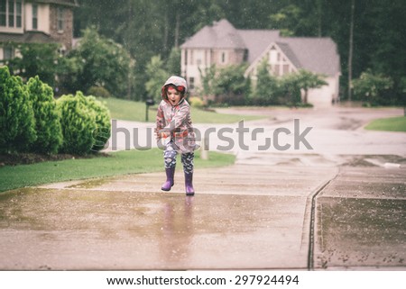 Toddler running in the rain
