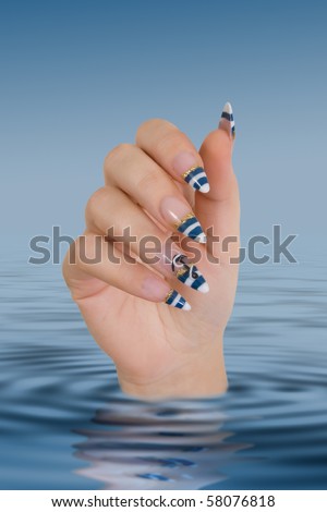 Female hand with a fancy manicure sticking out from water