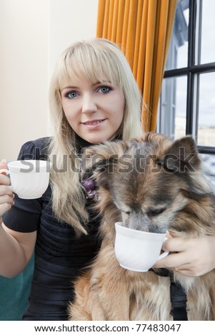 Beautiful woman and her dog having their tea