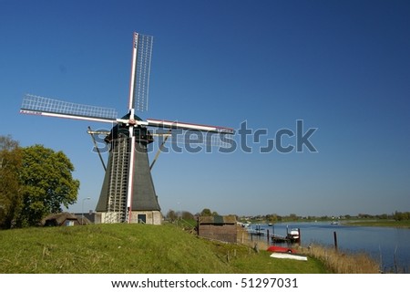 Dutch windmill on the river in Europe, The Netherlands, Nederhemert