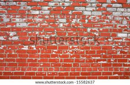 Decayed brick wall covered by a red paint