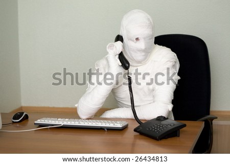 Bandaged boss calling on telephone in office
