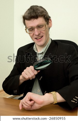 Person examines a watch through a magnifier
