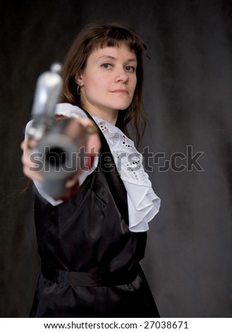The girl - pirate with ancient pistol in hand on a black background
