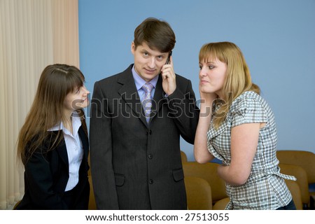 The man speaks by a mobile phone in the presence of two girls