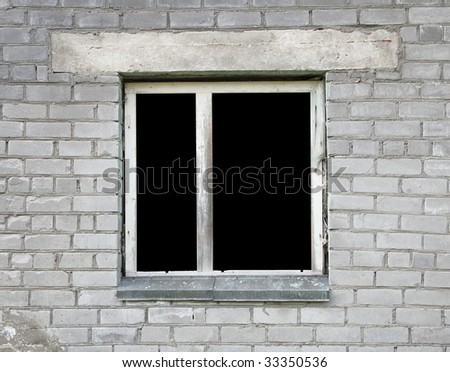 Empty dark window of the thrown old building