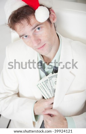 The businessman in a white suit and a Christmas cap hides money in a pocket