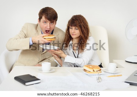 Two young businessmen lunching at the workplace