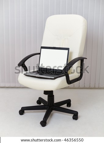 Laptop sits in a leather chair for the manager
