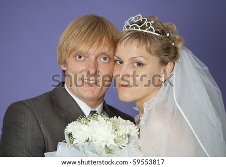 The first family portrait of the groom and the bride on violet background