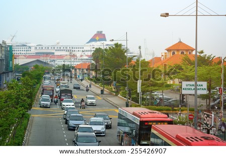 MALAYSIA, PENANG, GEORGETOWN - CIRCA JUL 2014: Traffic flows away from the passenger pier on this street near the port. A passenger cruise ship can be seen in the background.