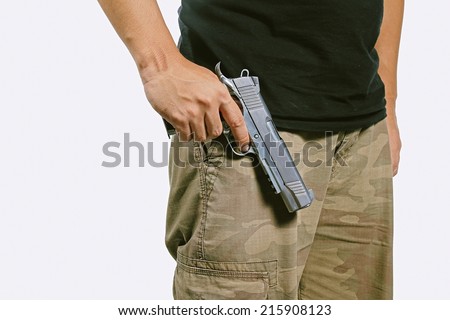 Man in a camouflage pants holding a gun, Semi-automatic handgun, Army, 45 pistol. (Color Process)