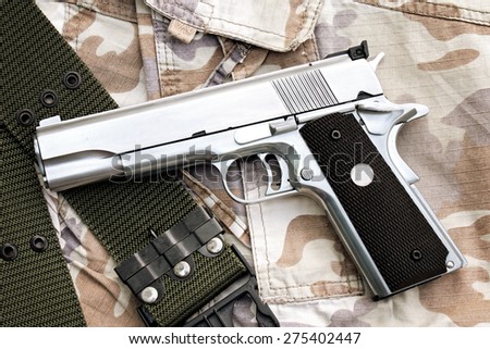 Semi-automatic handgun on camouflage background, Gun on Military texture, .45 pistol. (Color Process)